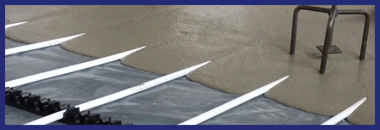 Liquid screed flowing over underfloor heating pipes