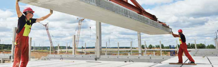 Two workers levelling a large fibre-reinforced concrete floor slab
